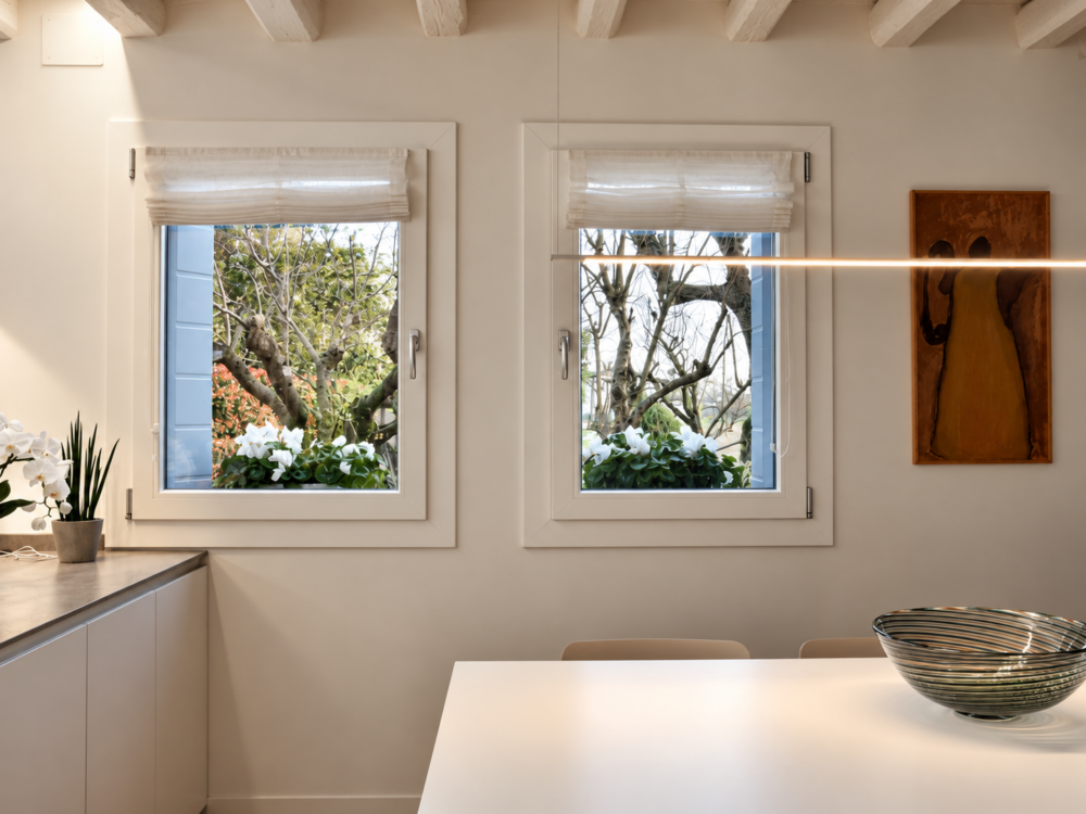 Cucina con finestre in PVC bianche e tende a pacchetto